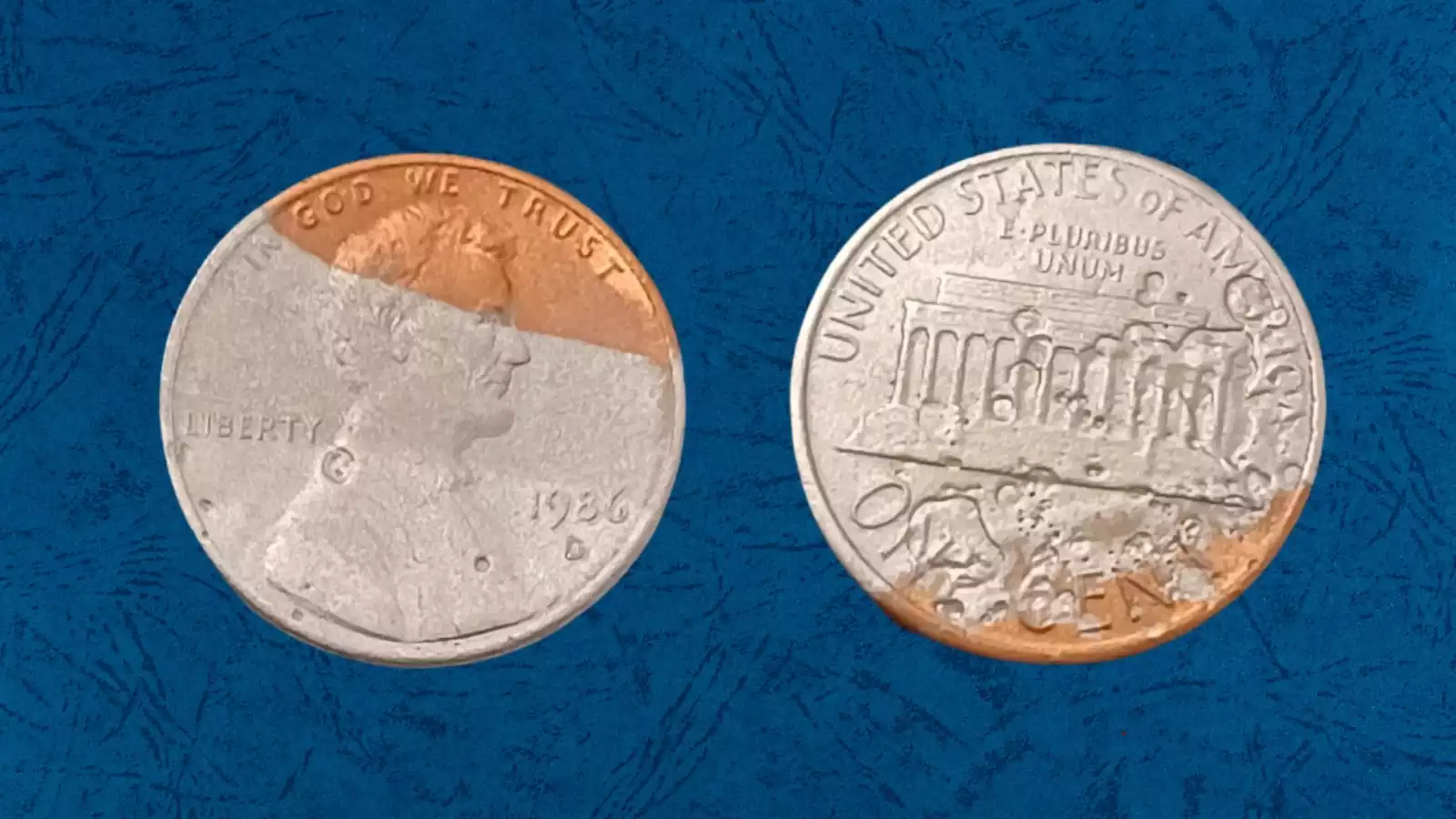 1986 Lincoln penny missing plating error showing exposed silvery zinc core patches contrasting with normal copper surface